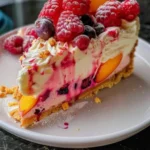 Slice of Berry Peach Cheesecake with fresh berries and peach slices on top