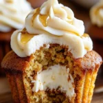 Carrot cake cheesecake cupcakes with maple frosting on a rustic wooden table.