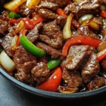 Plate of delicious Chinese pepper steak with bell peppers and onions.