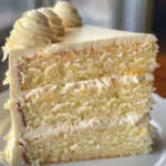 A slice of heavenly white chocolate cake with pineapple filling, beautifully decorated.