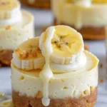 Delicious mini banana pudding cheesecakes topped with whipped cream and banana slices.