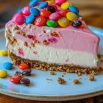 Pink Paradise No-Bake M&M Cookie Dough Cheesecake topped with colorful candies
