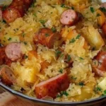 Plate of Polish sausage with sauerkraut and potatoes served on a wooden table