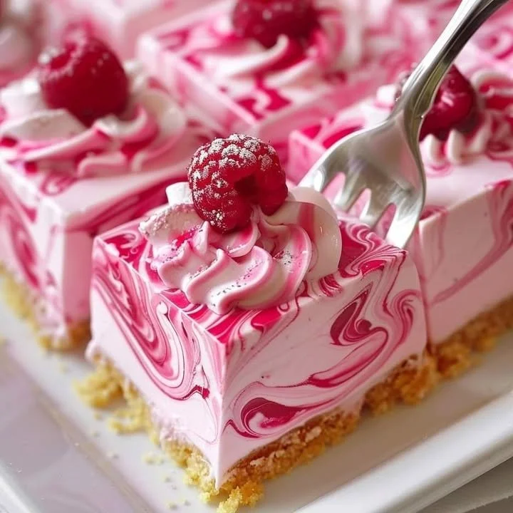 Delicious Raspberry Cheesecake Bars topped with fresh raspberries.