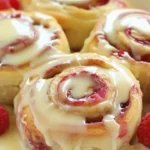 Freshly baked raspberry cinnamon rolls with a drizzle of lemon glaze