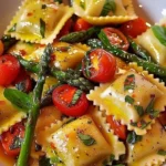Homemade ravioli with tomatoes, asparagus, garlic, and herbs served on a plate.