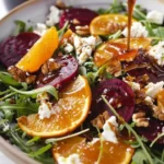 Arugula and citrus salad topped with goat cheese in a colorful bowl