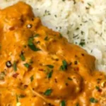 Delicious butter chicken served with rice and naan on a plate