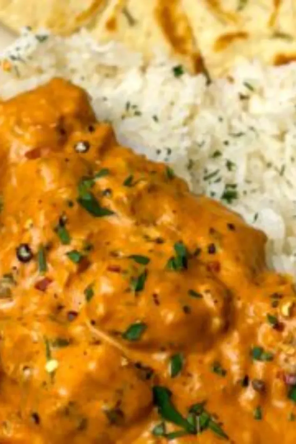 Delicious butter chicken served with rice and naan on a plate
