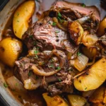 Cider braised beef served with apples and onions in a savory sauce