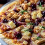 Cranberry Chicken and Brie Pizza topped with fresh ingredients and herbs