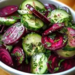 Cucumber and beetroot salad topped with herb dressing in a bowl