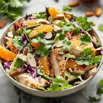 Exotic citrus almond chicken crunch served on a plate with vibrant greens.