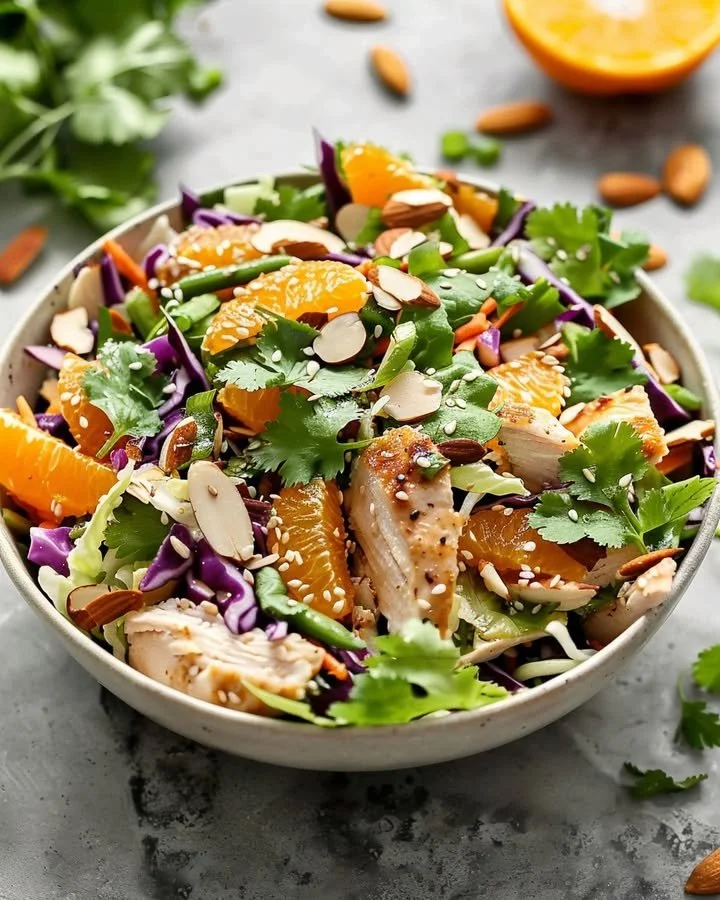 Exotic citrus almond chicken crunch served on a plate with vibrant greens.