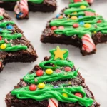 Festive Christmas Tree Brownies decorated with green icing and colorful sprinkles
