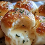 Gooey garlic butter cheese-filled biscuit bombs on a wooden board