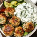 Plate of Greek chicken meatballs served with creamy homemade tzatziki sauce.