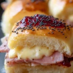 Ham and Cranberry Sliders topped with melty cheese on a platter.