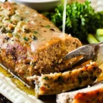 Deliciously baked hearty homestyle meatloaf on a rustic wooden table.