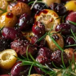 Mediterranean baked olives served in a rustic dish with herbs.