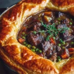 Savory beef pastry pie with vegetables inside flaky puff pastry