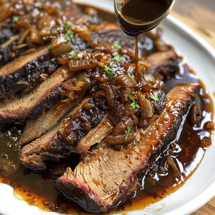 Slow cooker brisket served with balsamic onion gravy on a plate