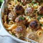 Delicious Swedish meatball pasta bake topped with melted cheese and fresh herbs