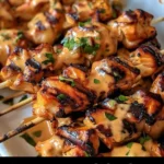 Air Fryer Bang Bang Chicken Skewers on a plate with a spicy sauce