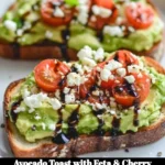 Avocado toast topped with feta cheese and cherry tomatoes on a plate.