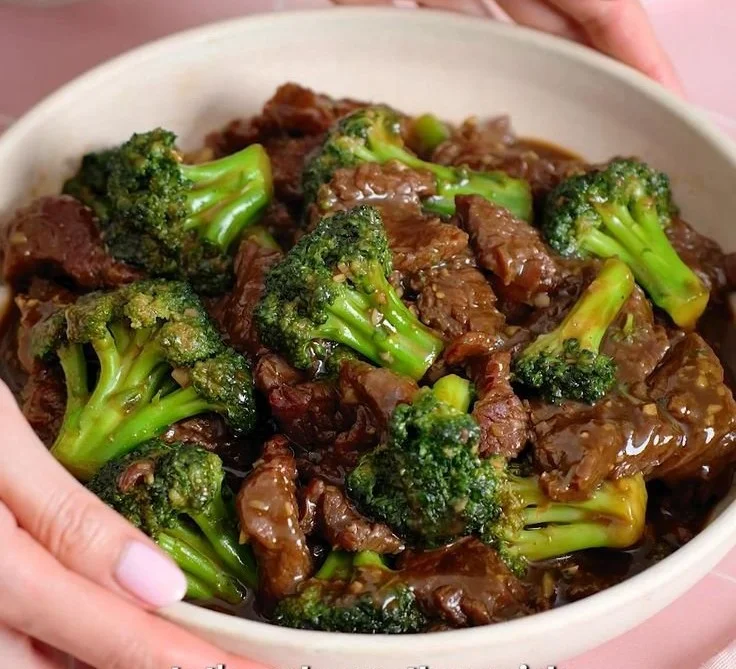 Delicious beef and broccoli stir-fry served in a bowl, garnished with sesame seeds.