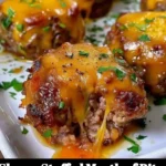 Cheesy stuffed meatloaf bites arranged on a platter, served as a tasty appetizer.