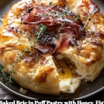 Baked Brie in Puff Pastry topped with honey, fig, and prosciutto.