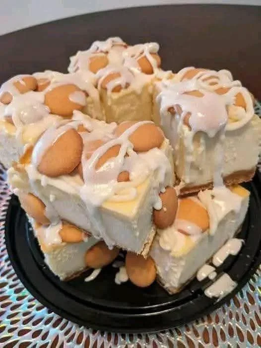 Delicious Banana Pudding Cheesecake Squares topped with banana slices and whipped cream