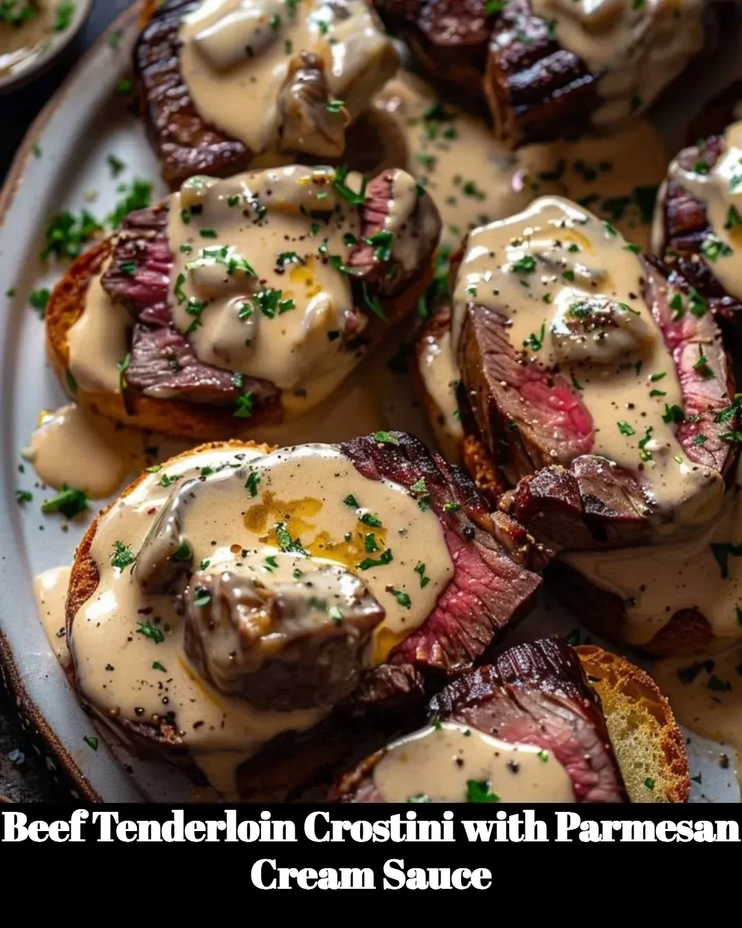 Beef tenderloin crostini with creamy Parmesan sauce on a wooden platter