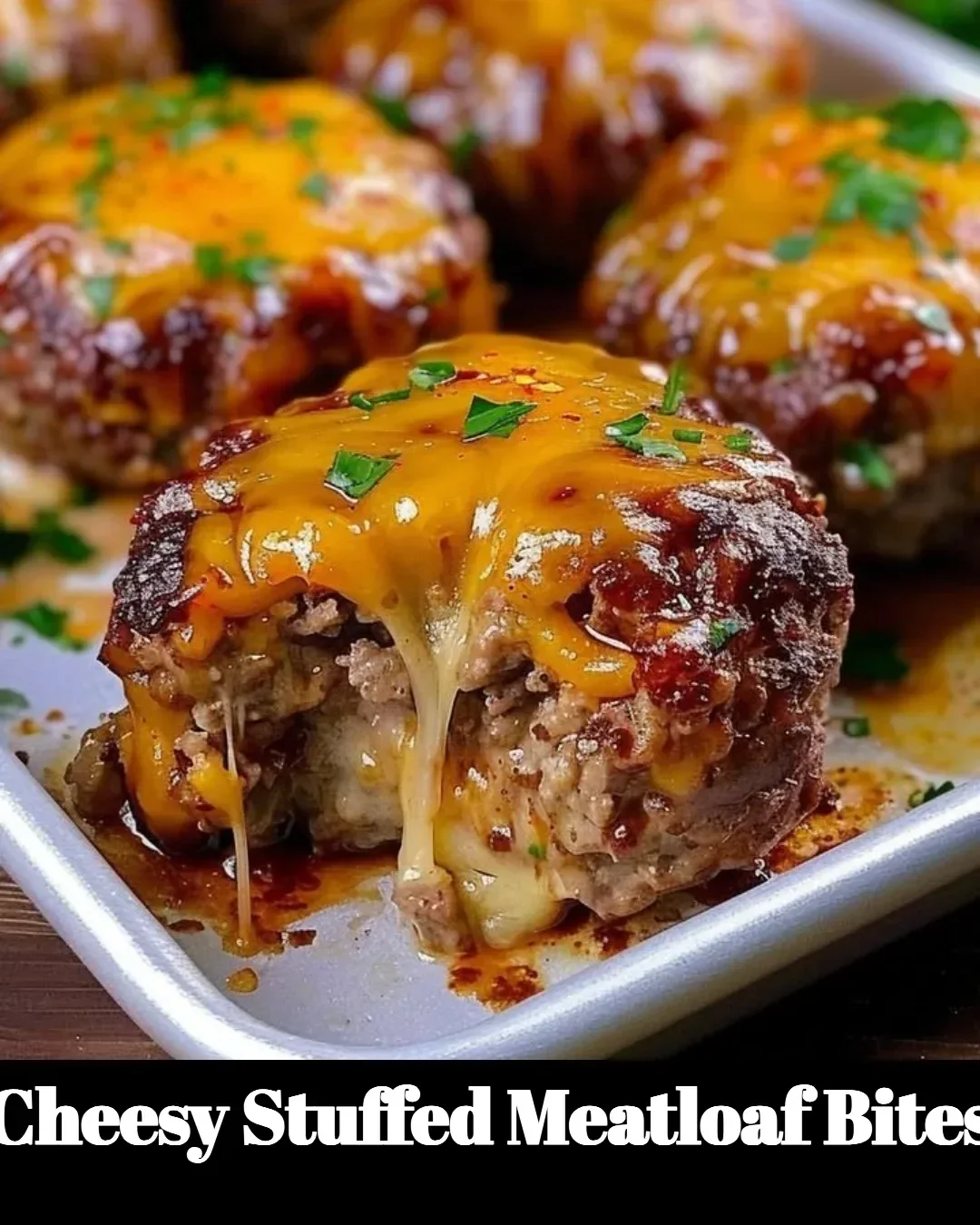Cheesy stuffed meatloaf bites served on a plate garnished with herbs