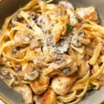 Plate of creamy Marsala chicken pasta garnished with herbs
