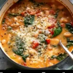 Bowl of Creamy Parmesan Tuscano Soup topped with herbs and cheese, served hot.