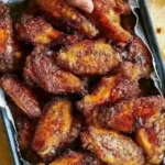 Crispy baked chicken wings served with dipping sauce on a platter.