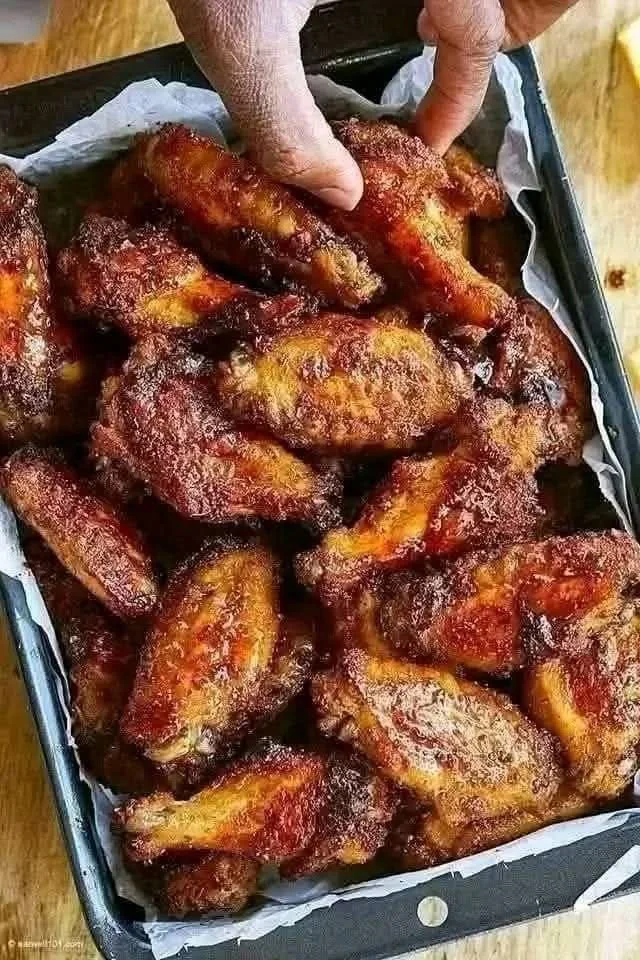 Crispy baked chicken wings served with dipping sauce on a platter.