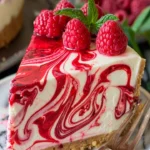 Decadent white chocolate raspberry truffle cheesecake topped with raspberry sauce