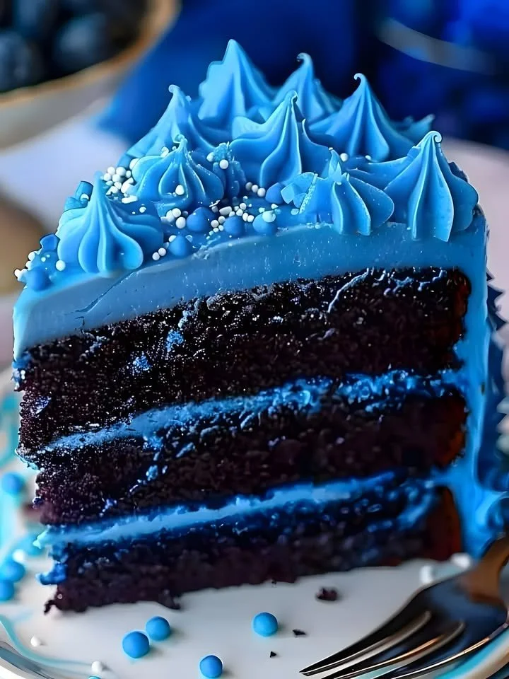A beautiful slice of Divine Blue Velvet Cake showcasing its rich color and texture.