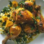 Saffron chicken garnished with citrus, showcasing vibrant colors and elegant presentation.