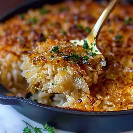 Bowl of French onion butter rice garnished with herbs and cheese.