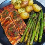 Garlic Herb Salmon served with asparagus and potatoes on a plate.