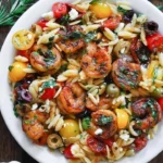 Plate of Greek Shrimp Orzo with feta, olives, and tomatoes