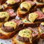 Grilled beef tenderloin crostini with Béarnaise sauce on a platter.