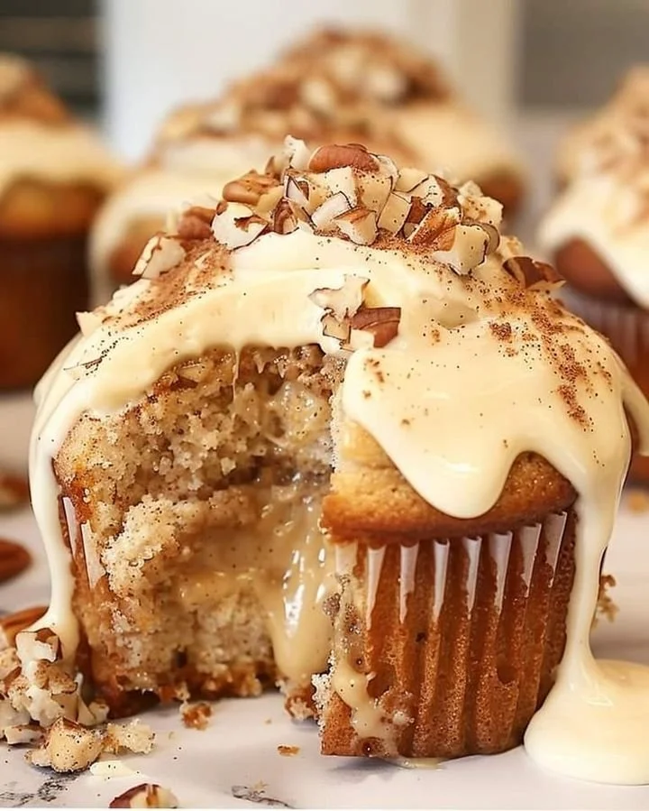 Banana cinnamon pecan cupcakes topped with frosting and pecans