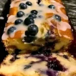 Sliced Lemon Blueberry Loaf on a wooden cutting board