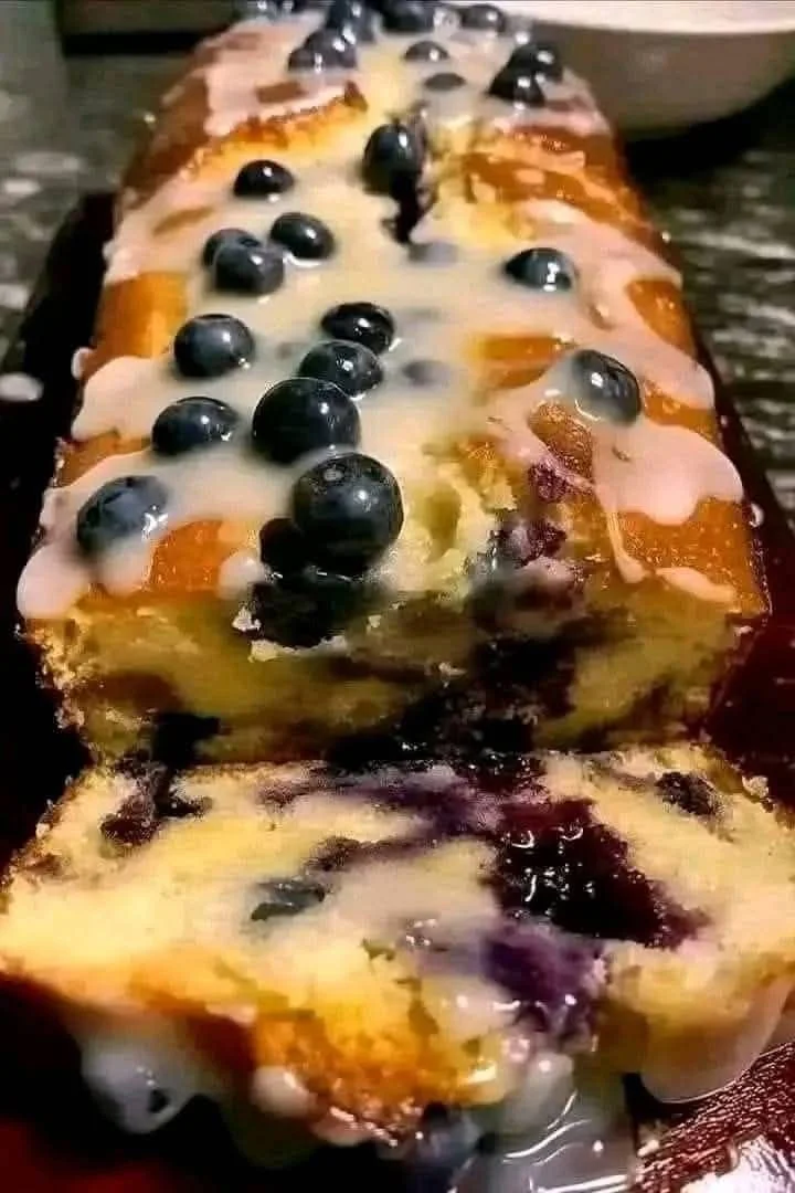 Sliced Lemon Blueberry Loaf on a wooden cutting board