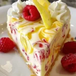 Lemon raspberry swirl cheesecake topped with fresh raspberries and lemon zest